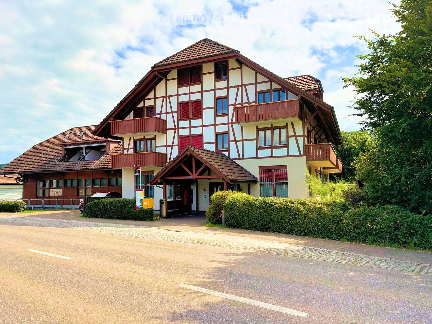 3 story house, red brick, white and brown exterior, brown roof, balconies, garden