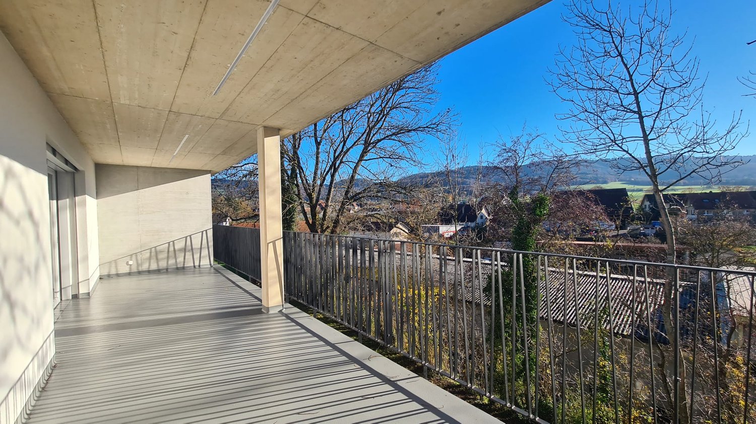 balcony with railings, concrete floor, outdoor view of valley and town