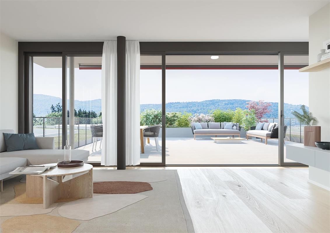 Sliding doors leading to balcony, white walls, wooden flooring, couches, coffee table, pillows, wooden chair, outdoor deck, table, mountains in the distance