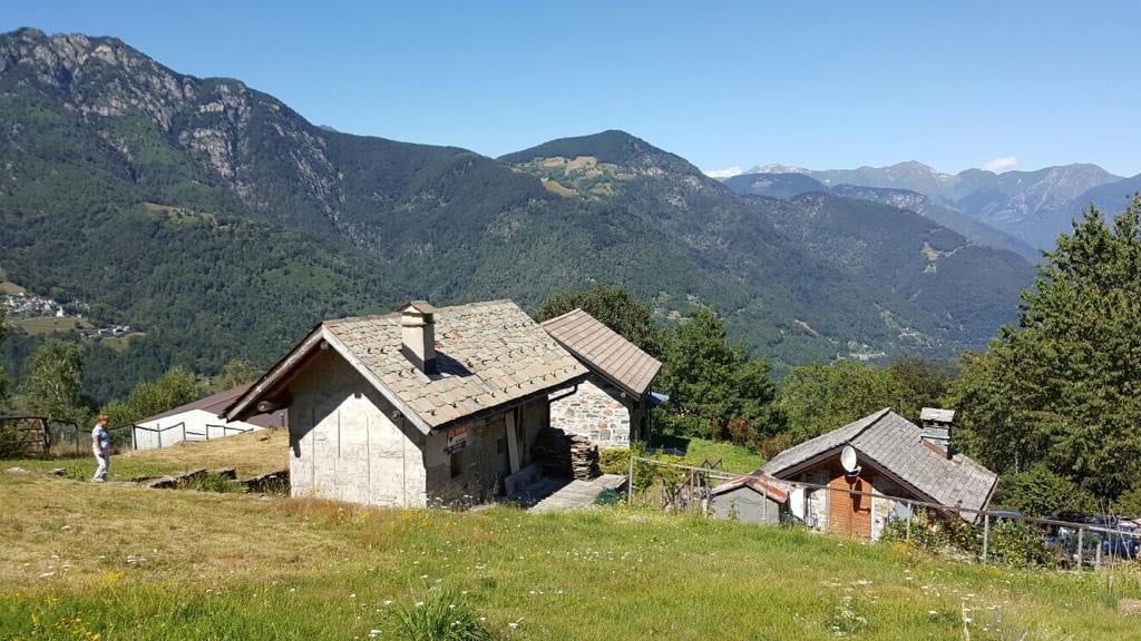 Mountain chalet with mountain view, two structures with stone walls, a fence