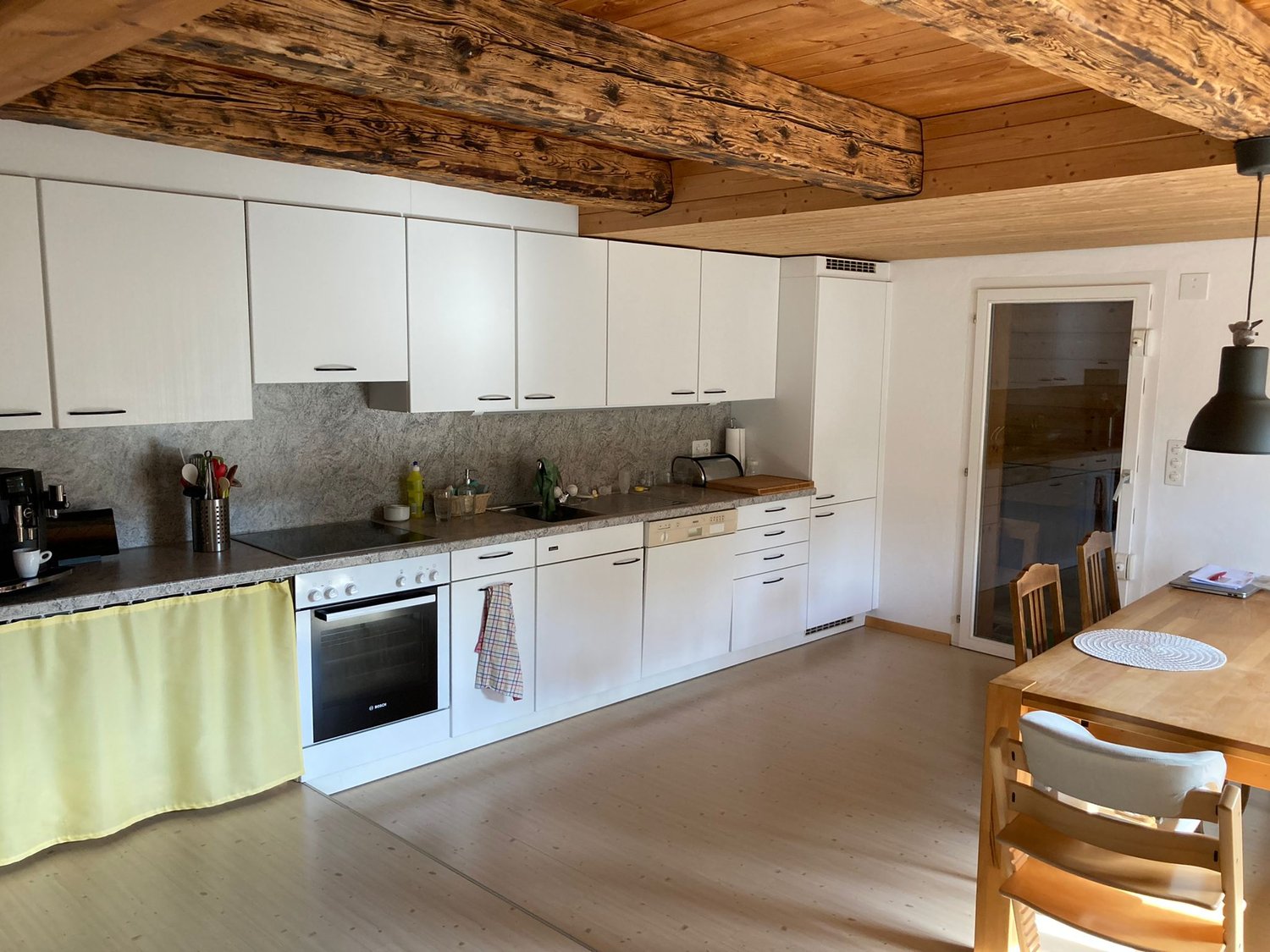 kitchen: granite countertop, white cabinets, stainless steel appliances, tiled floor, wooden beams