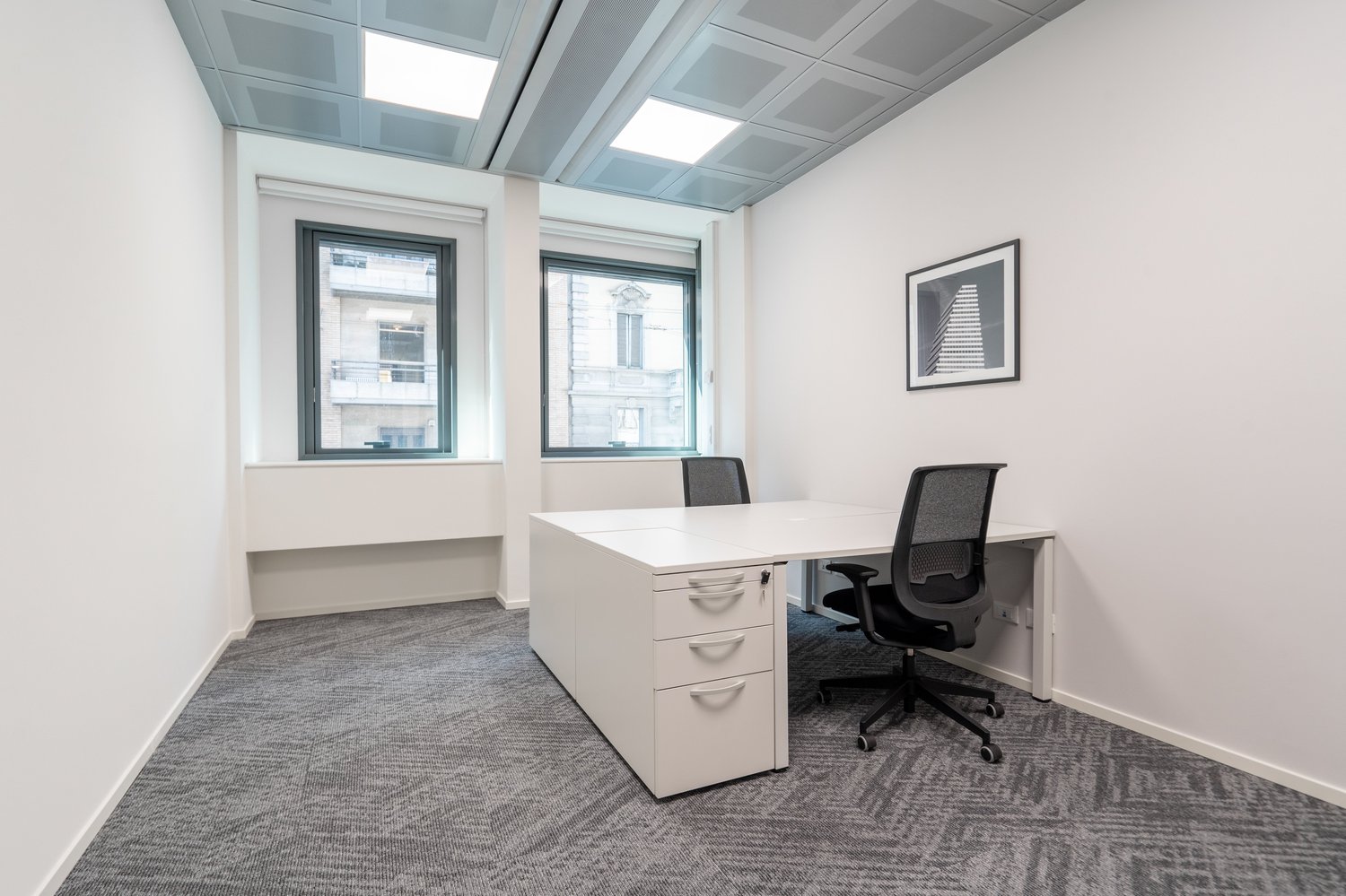 a desk with two chairs, modern decor, gray carpet, windows, picture frame