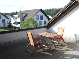 Balcony with table and chairs, view of the houses