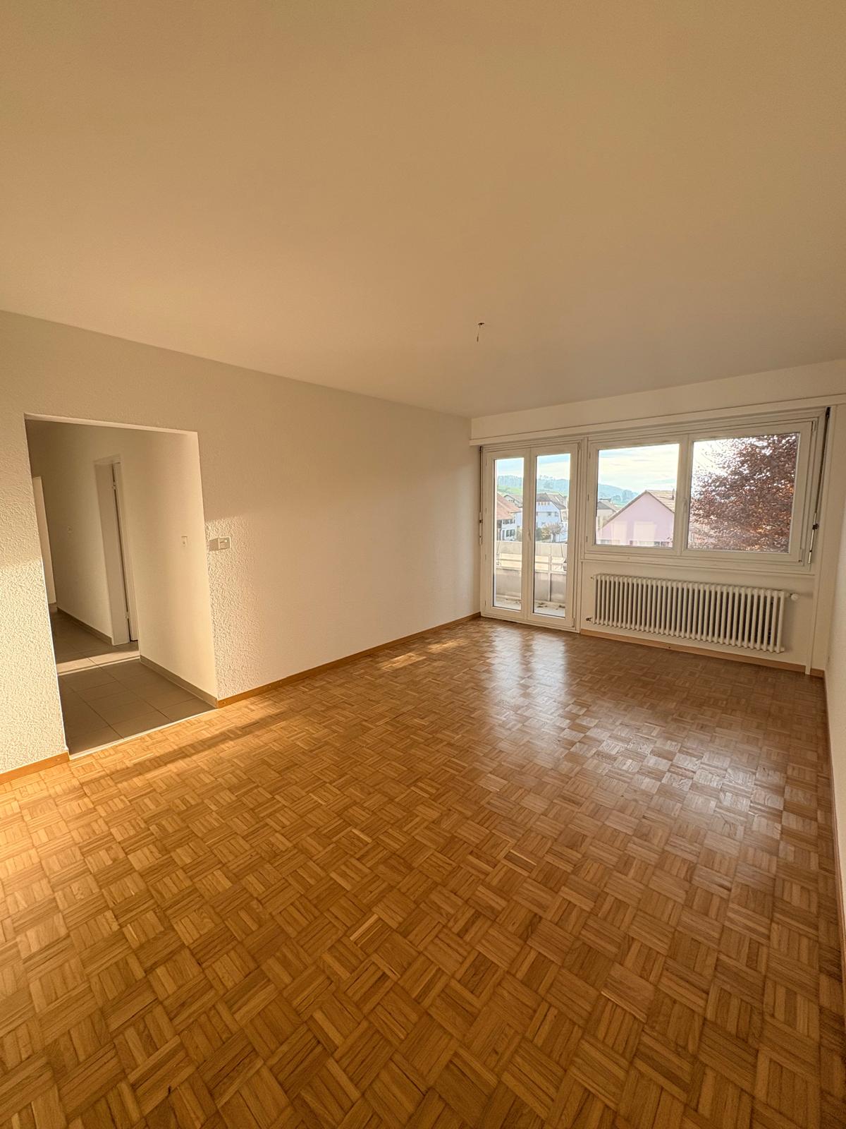 empty room, wooden floor, glass sliding doors, white walls, white ceiling, heater