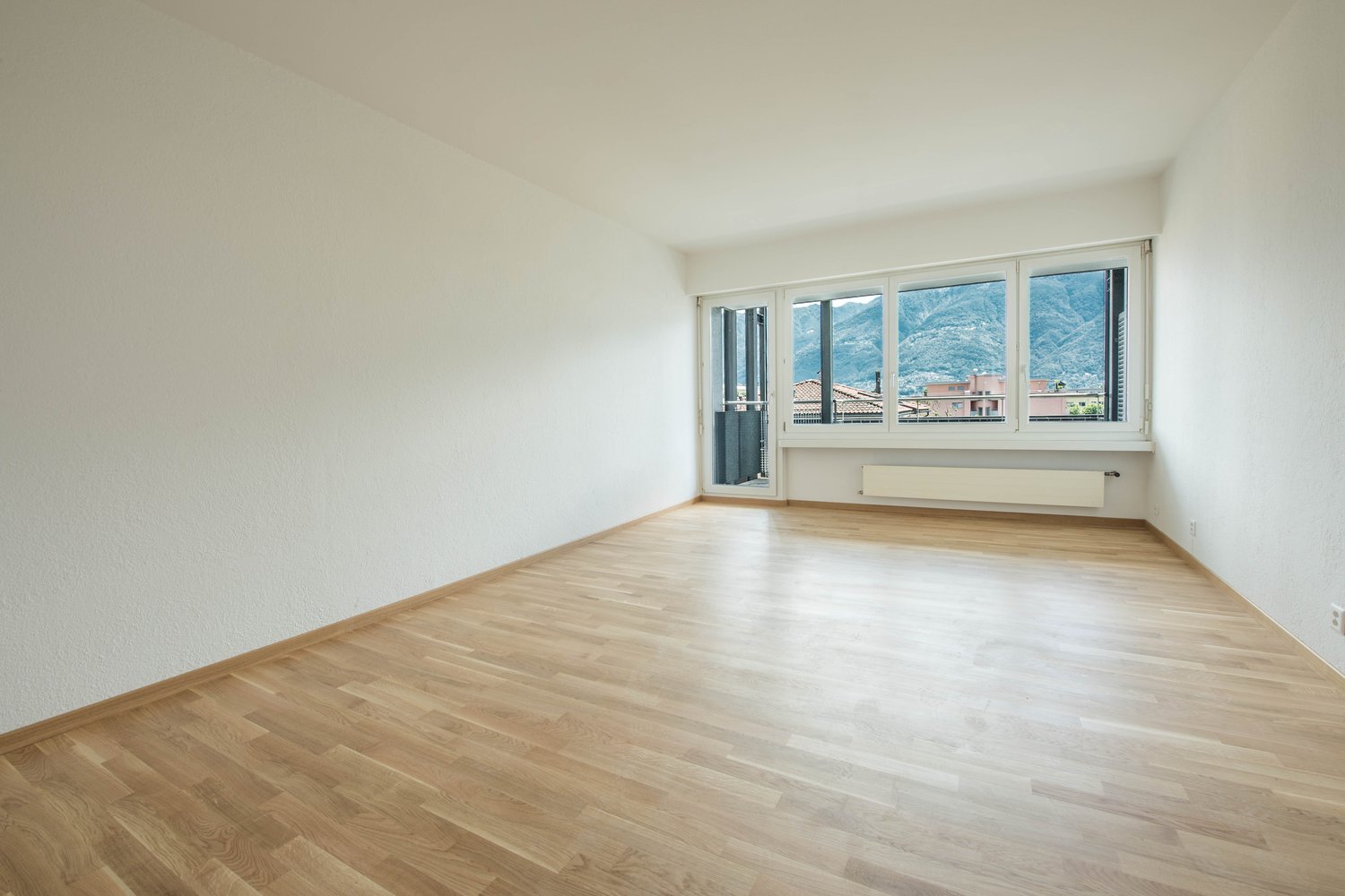 empty room, wooden floor, white walls, large windows, balcony