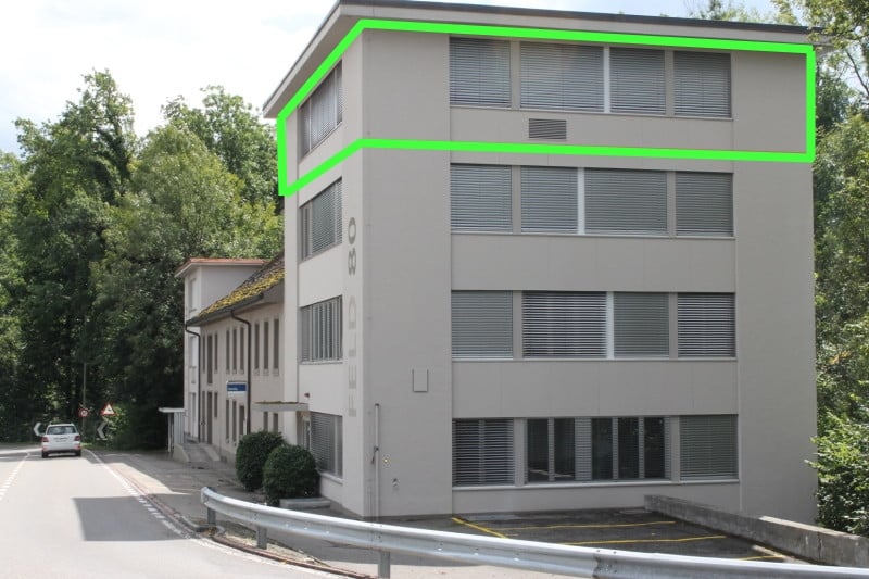 2 story building, large windows, driveway, green outline