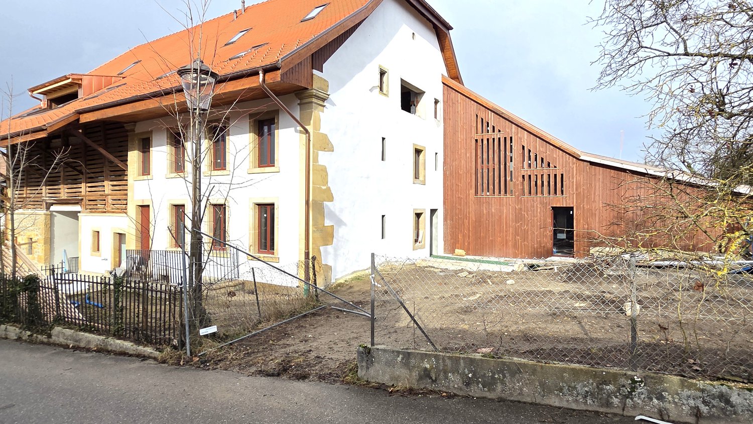 Modern 2 story house, wood exterior, red roof, large windows, balcony