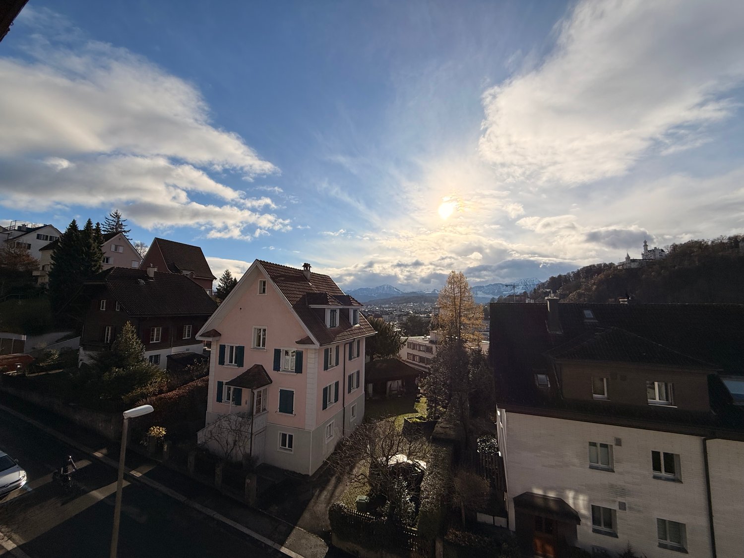 aerial view of residential area with 2 story houses, mountain in the distance, cloudy blue sky
