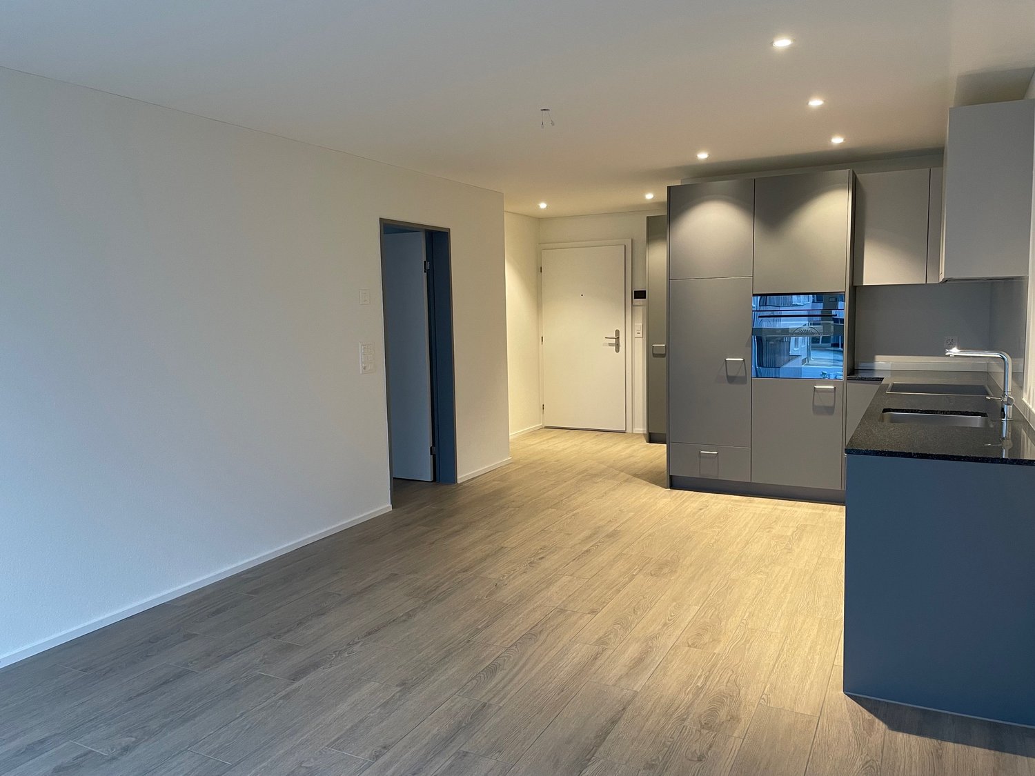 open plan kitchen, tiled floor, integrated dishwasher, white wall, kitchen cabinets, white sink, two sinks, faucet