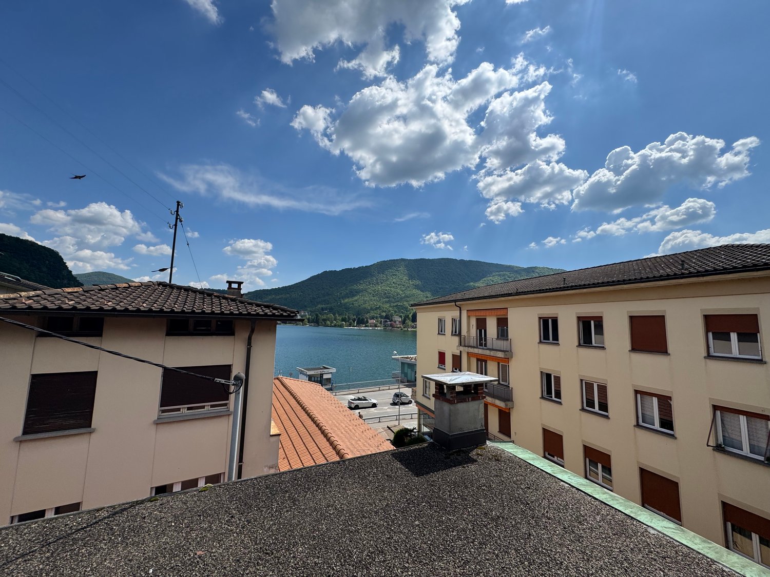 Two residential buildings with mountain view, lake, and distant mountain range