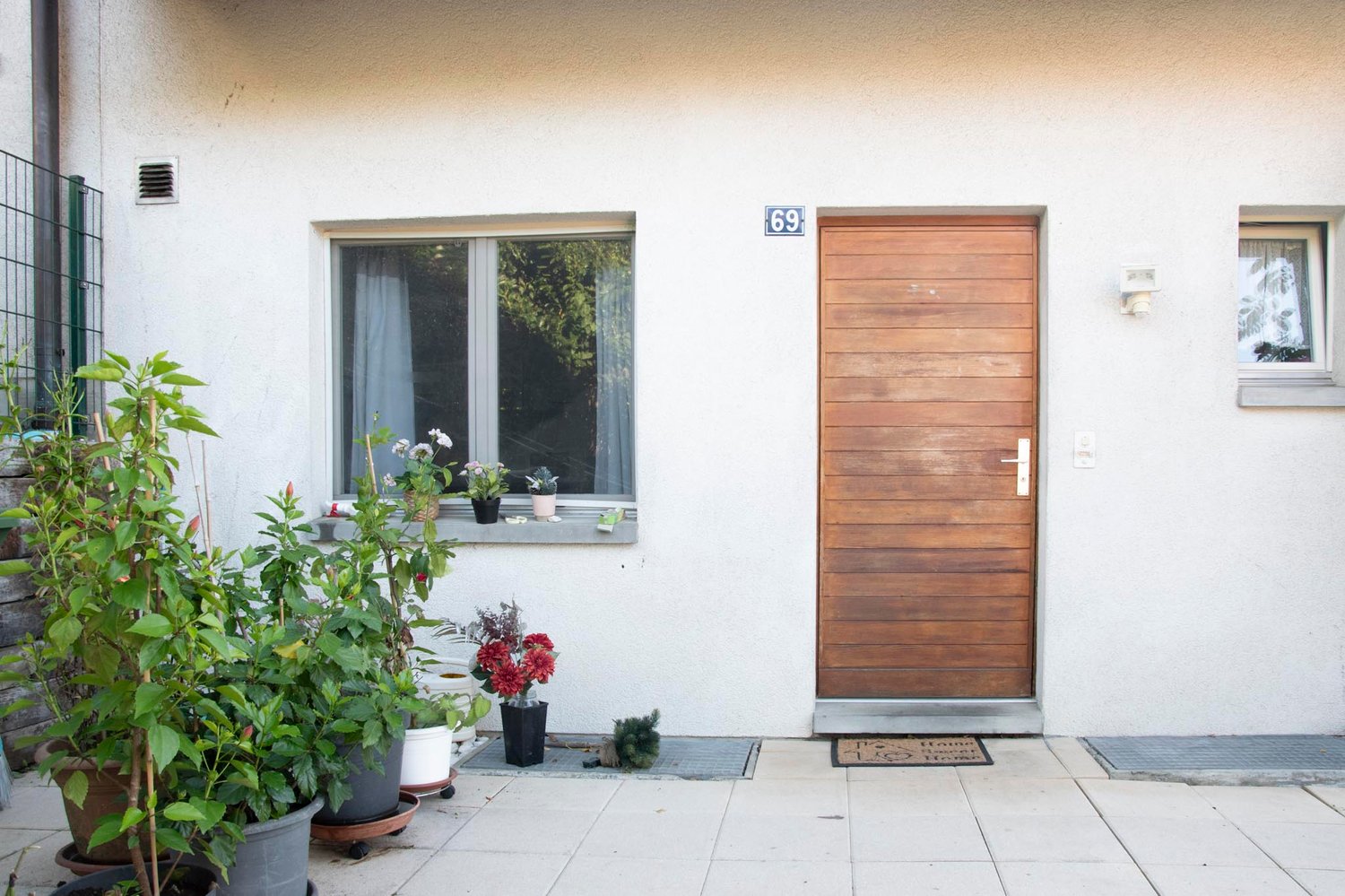 single-family house, white exterior, entrance door, window, potted plants