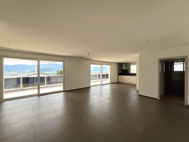 Open living room with tiled floors, sliding glass doors, high ceilings, view