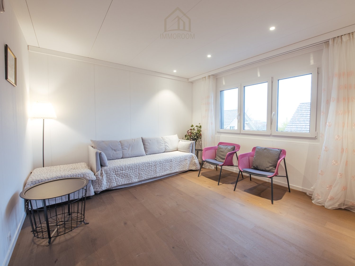 Sofa, pillows, coffee table, chairs, windows, floor lamp, picture frame, white curtains, potted plant