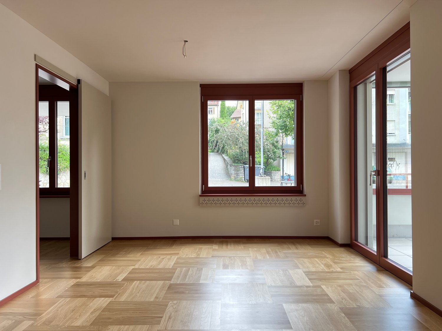 empty room, wooden floor, sliding glass doors, large window with balcony