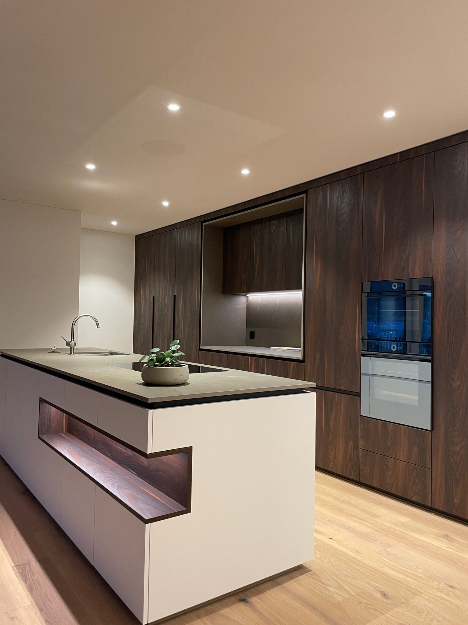 modern kitchen with white marble countertop, built-in appliances, wooden cabinets, and a central island