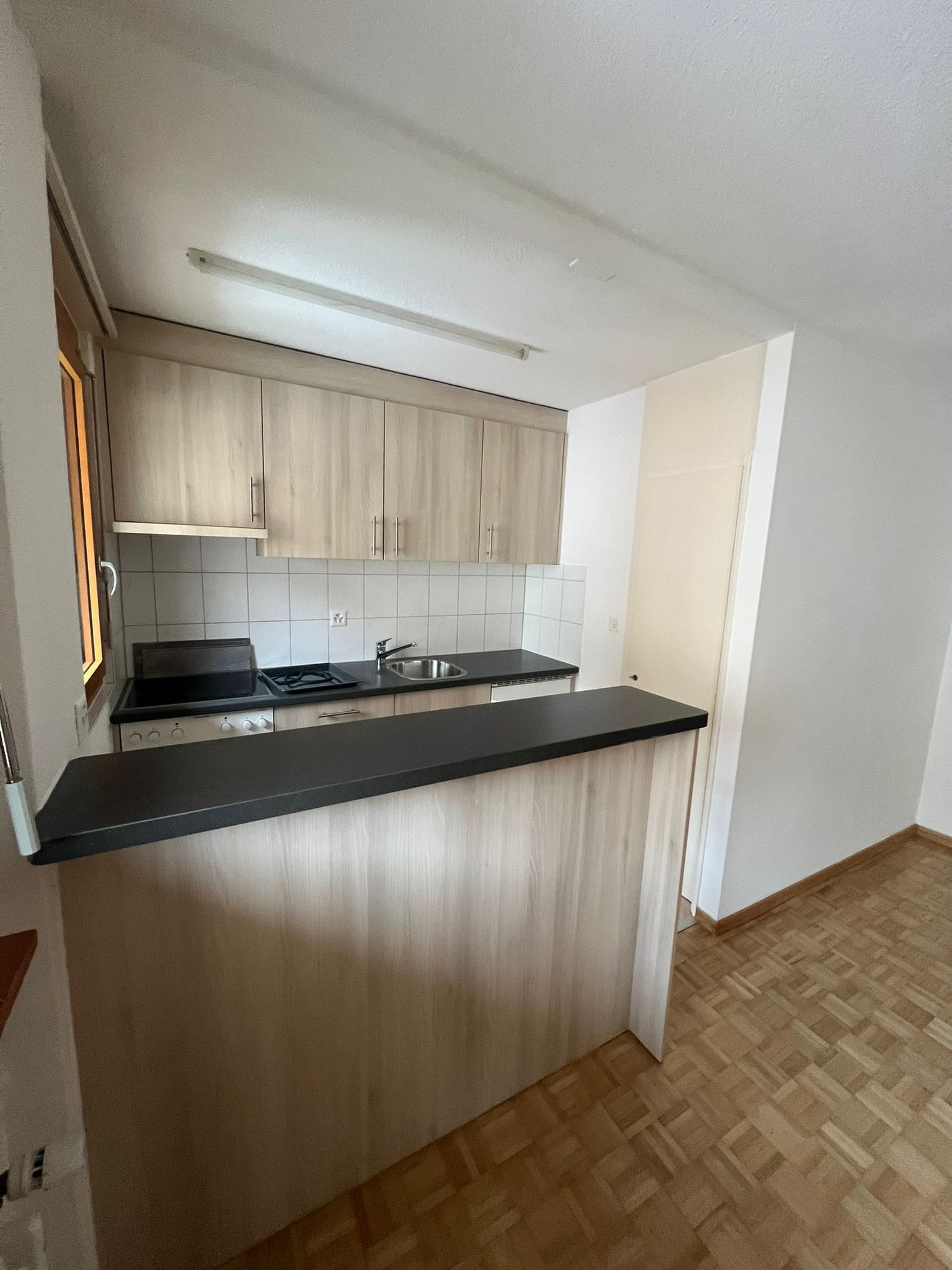 kitchen with wooden countertops, kitchen island, wooden cabinets, black countertop, sink, gas stove, electrical outlets, window