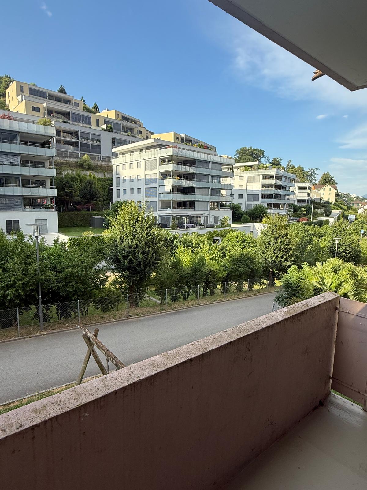 Multi-storey building complex, fenced off area, street with greenery