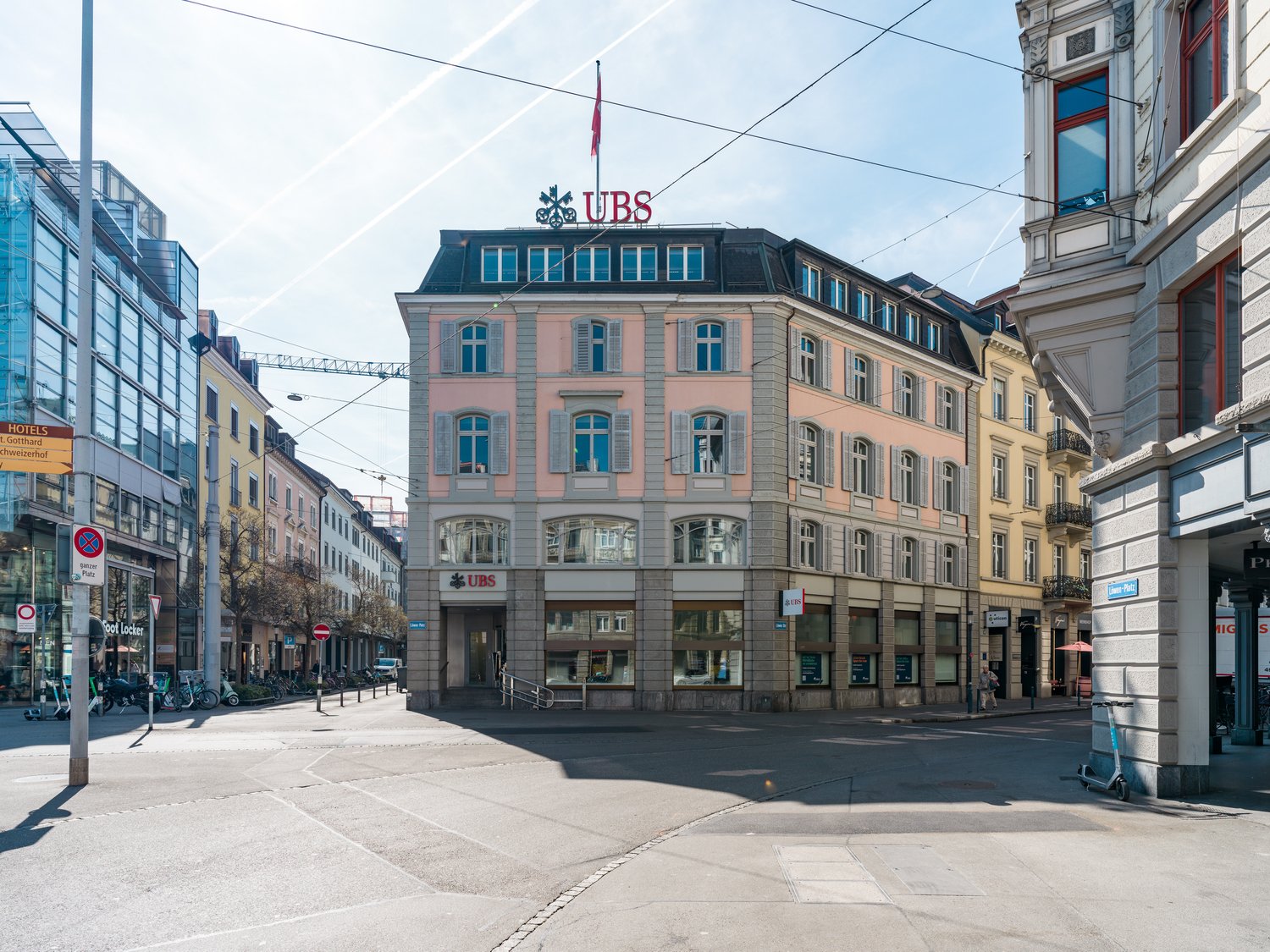 A 4-story commercial building with the UBS bank sign on top, surrounded by other buildings