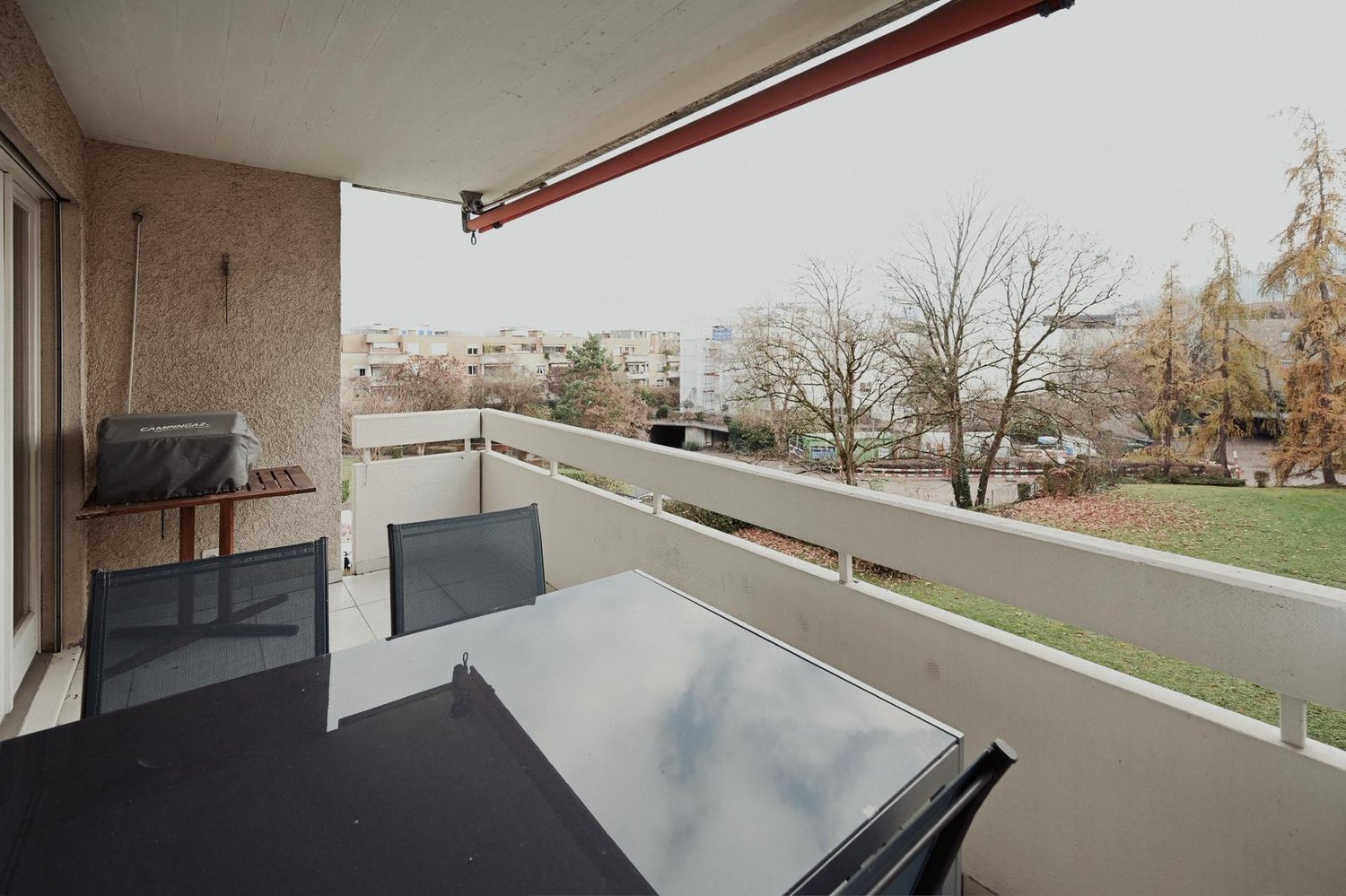 Balcony with table and chairs, covered balcony, grassy area
