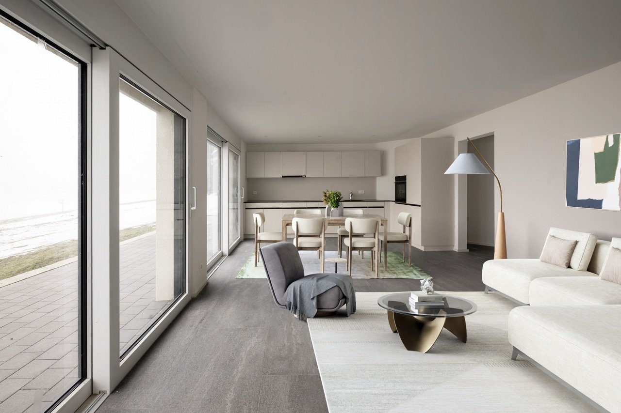 large living room with grey flooring, white walls, grey armchair, white couches, large glass doors, open-plan kitchen, dining table, large windows, floor-to-ceiling