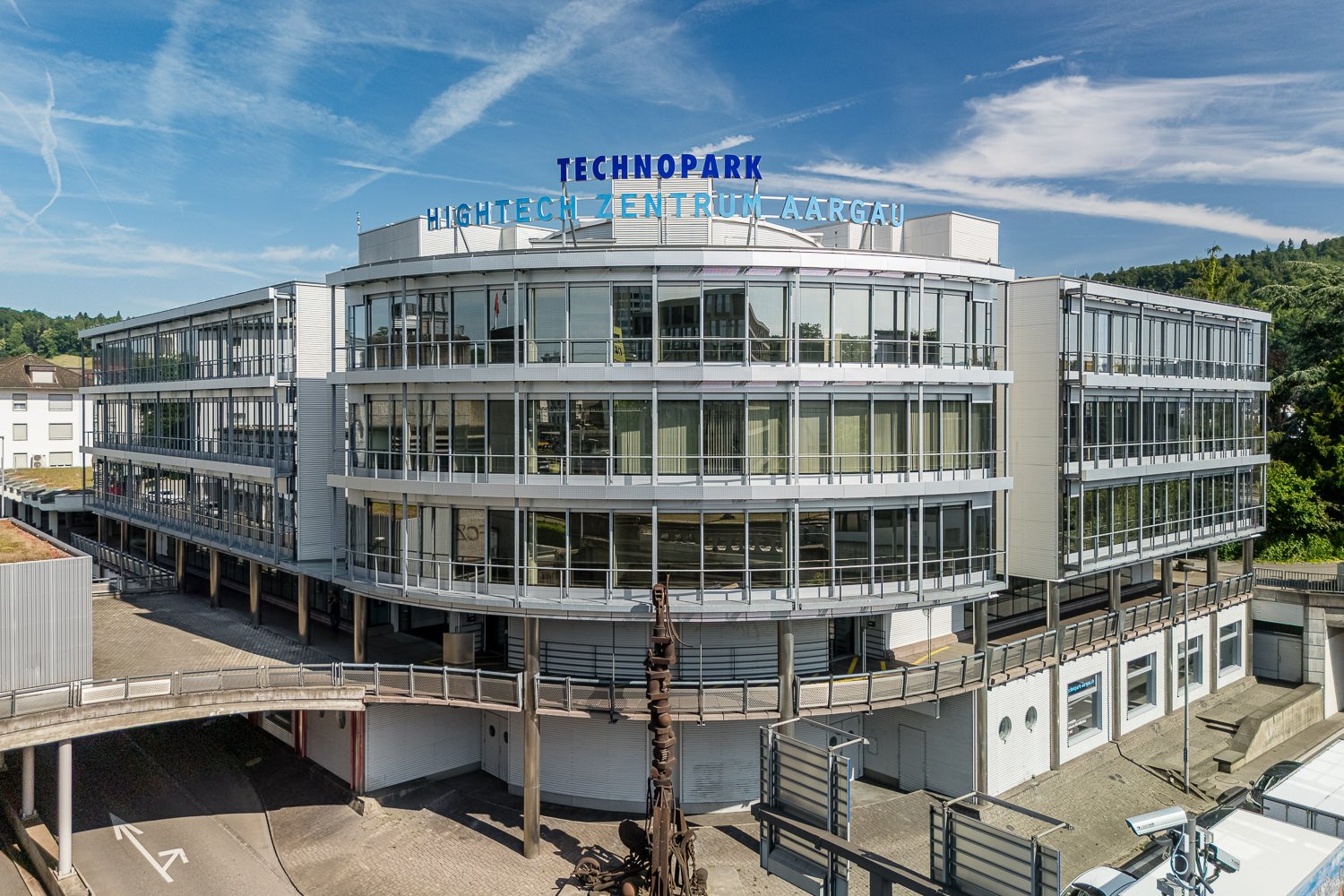 TECHNOPARK building, multiple floors, glass walls, curved design, green rooftop