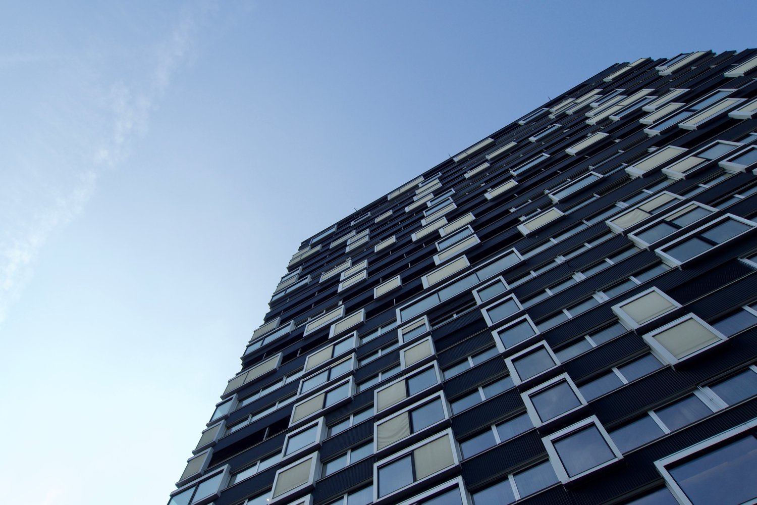 Modern high-rise building with glass windows and black frames