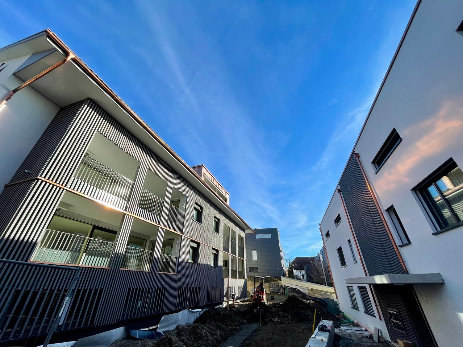 multi-story building, balconies, construction in progress, nearby another building