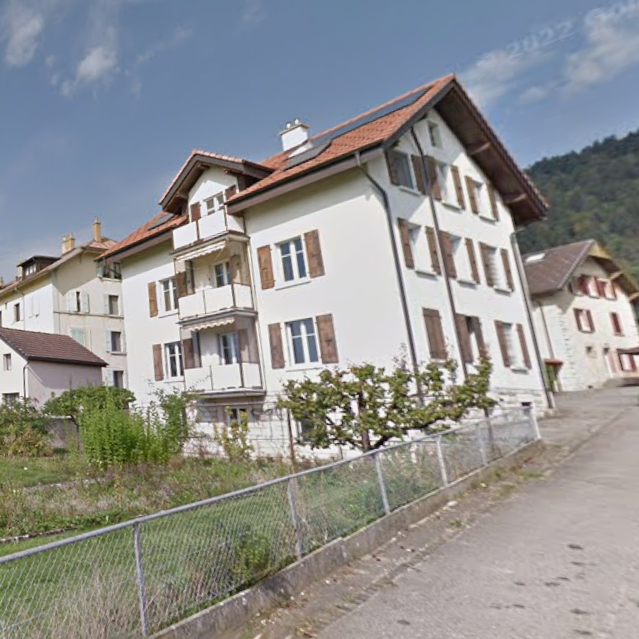 4 story house, white painted wall, red roof, multiple windows, small garden in front