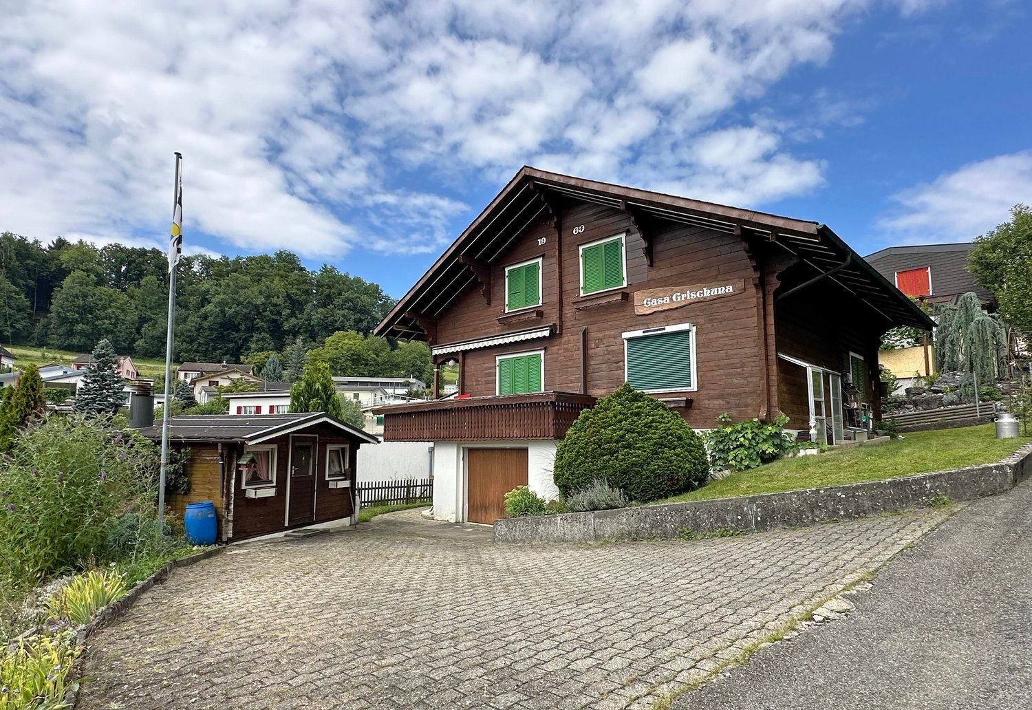 wooden facade, brick basement, large terrace, garage, flag, greenery