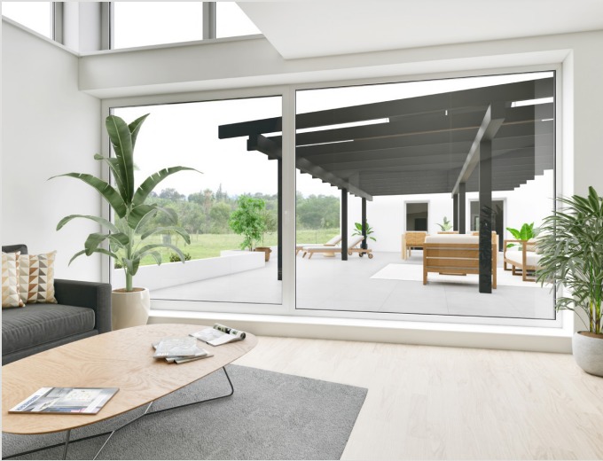 modern living room, gray couch, wooden coffee table, plants, large windows with glass sliding doors to a patio