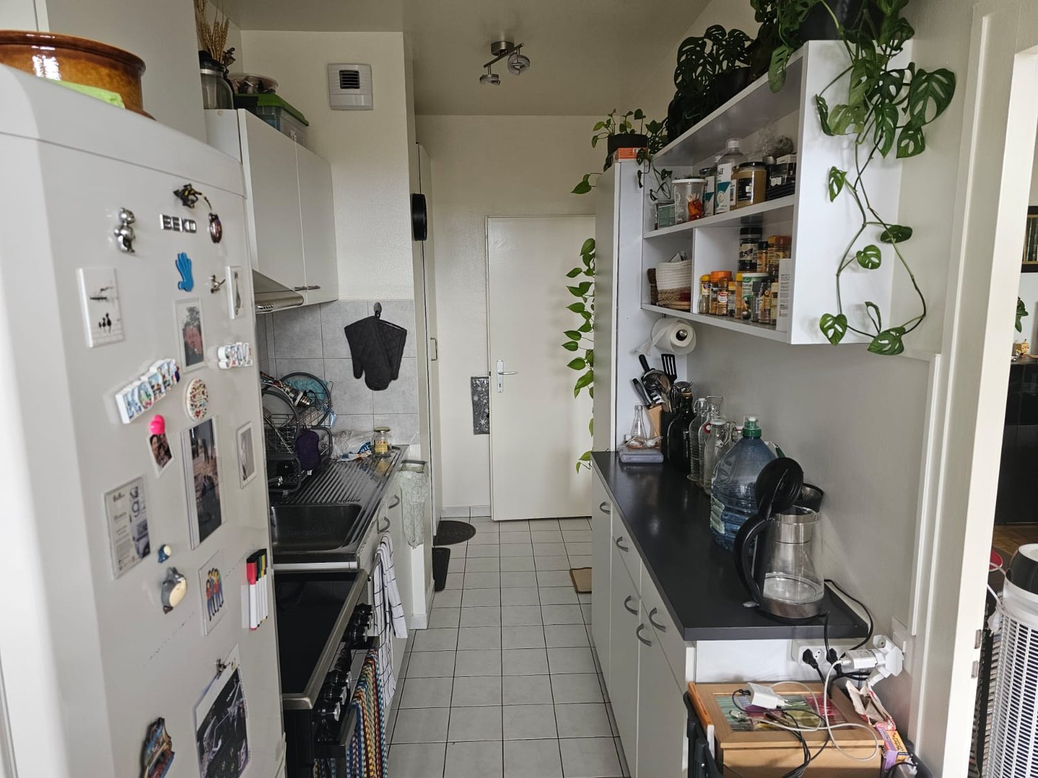 white appliances, gas stove, refrigerator, cabinets, countertop, tiled floor