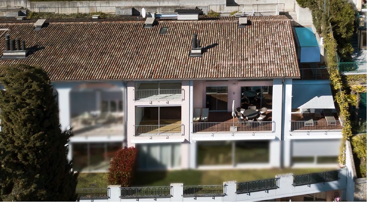 Aerial view of a modern house with a brown roof, glass windows, and balconies.
