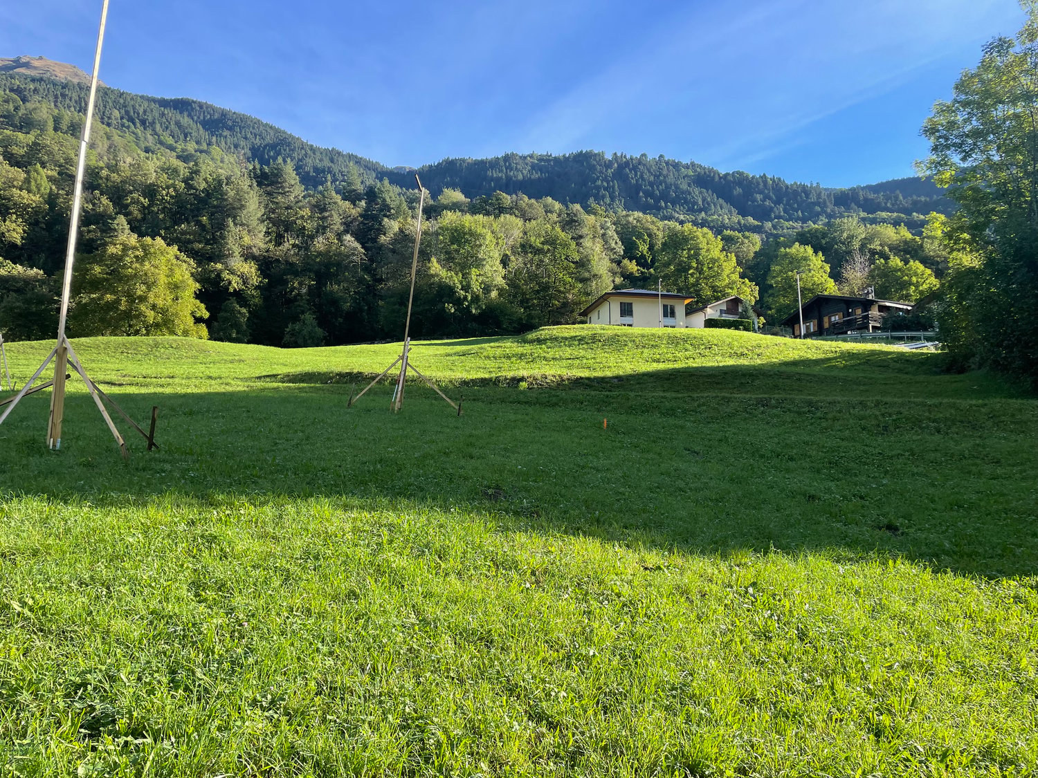 hill, green lawn, two houses at the back, clear view of the mountains