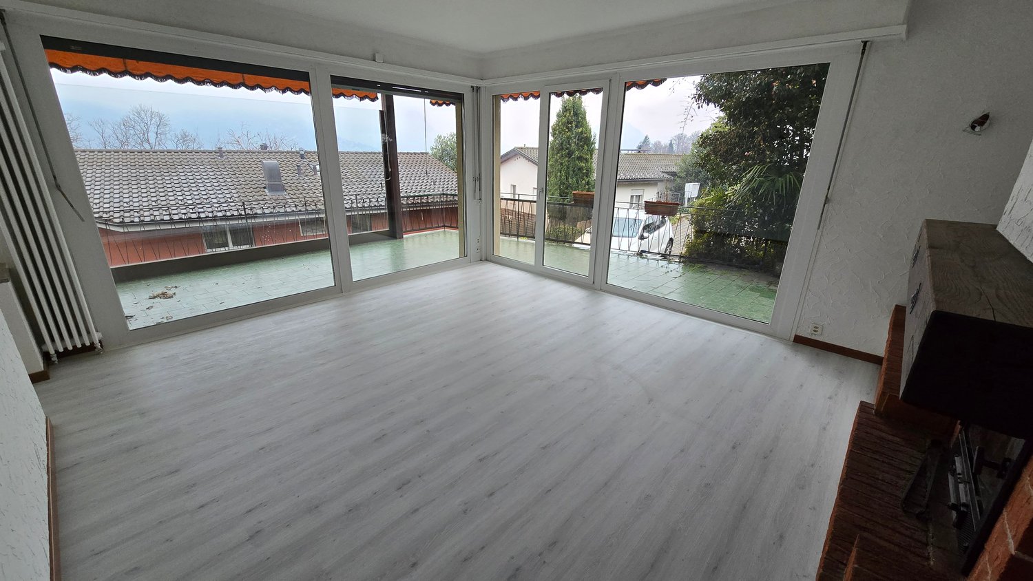 large windows, terrace, white laminate floor, fireplace, outside view