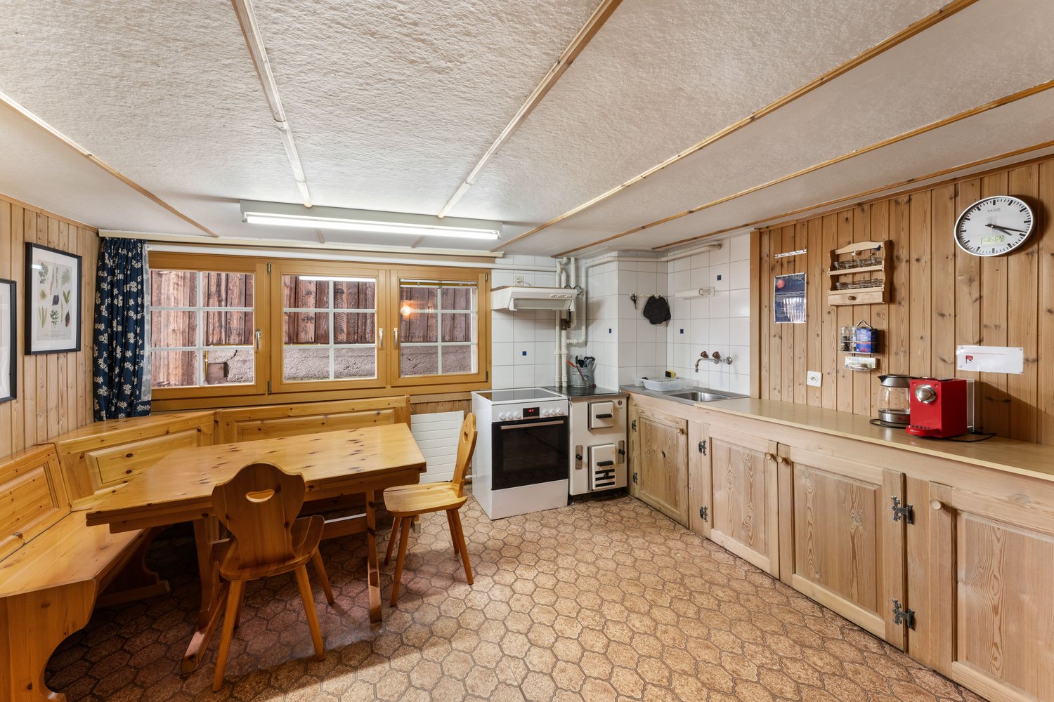 kitchen with dining area, wooden furniture, white appliances, tiled floor, wooden walls, large windows