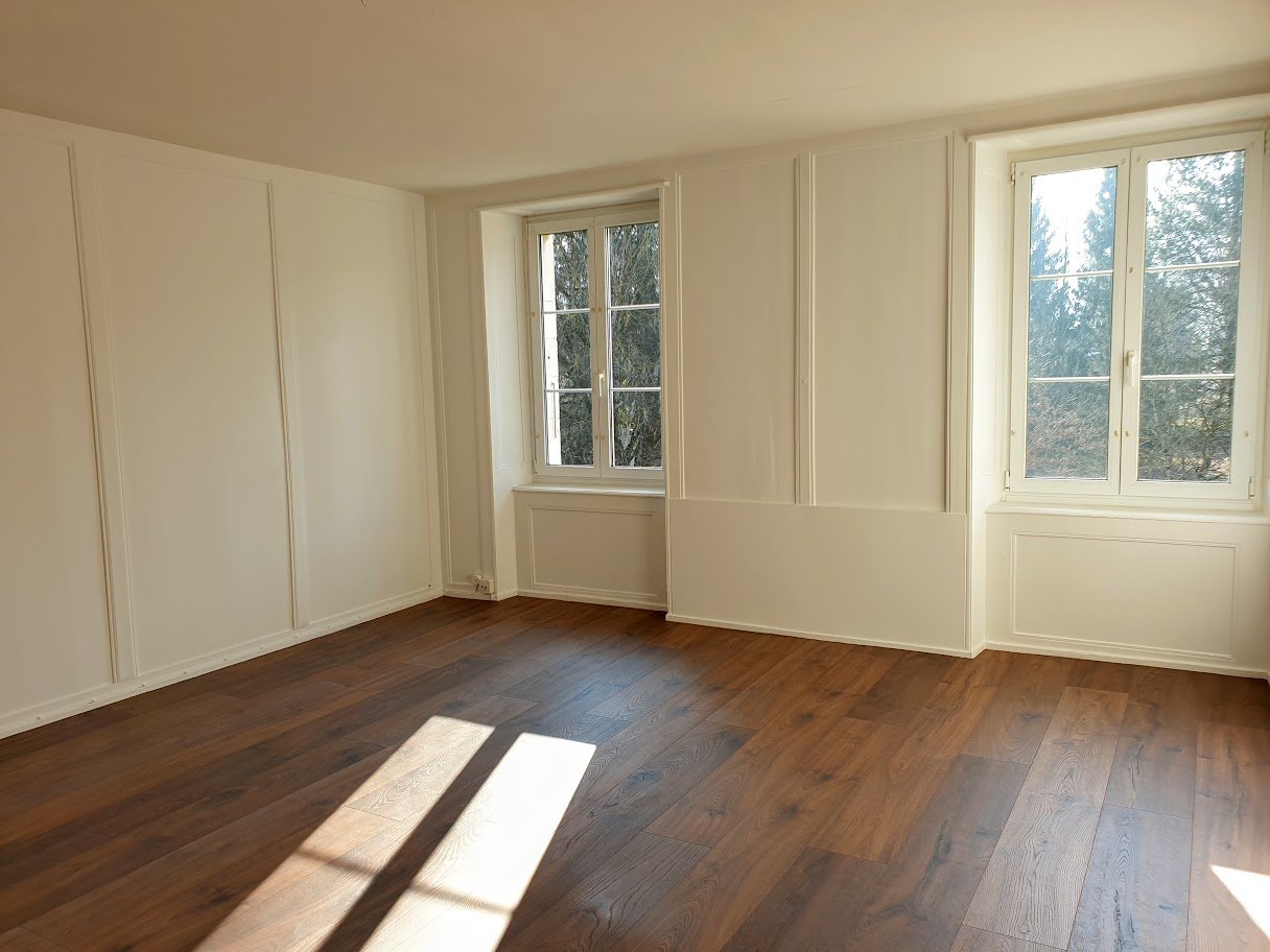 empty room, wooden floor, two large windows, white walls