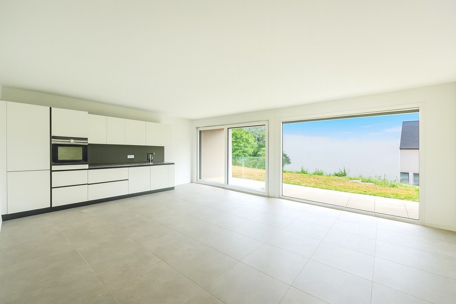 white cabinets, modern built-in appliances, tiled floor, large windows with access to the outside