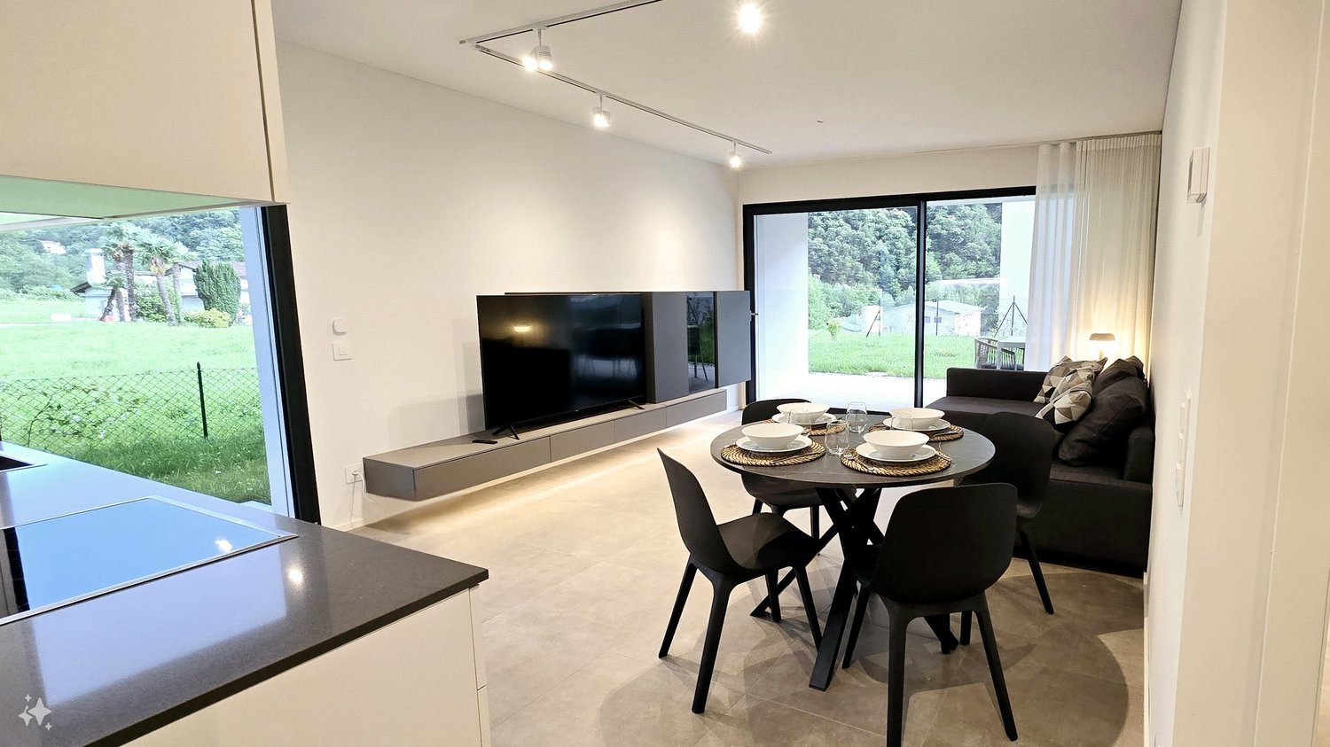 living room with TV and large windows