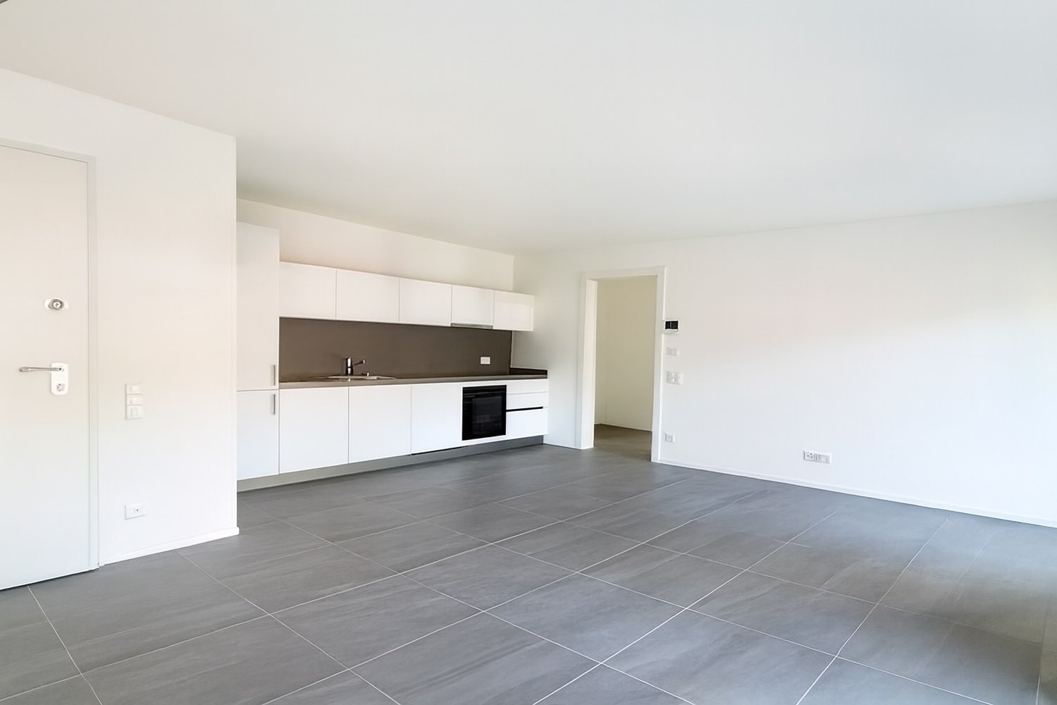 empty kitchen with white cabinets, modern design, gray tiles, sink with faucet, electric oven