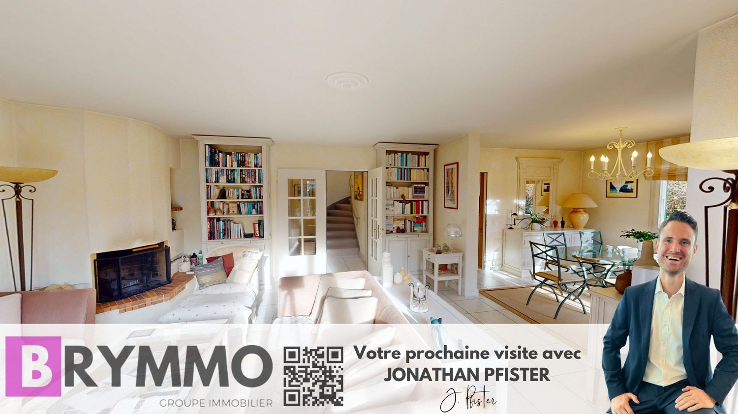 modern living room with fireplace, bookshelves, large sofas, round tables, chandelier, lamps