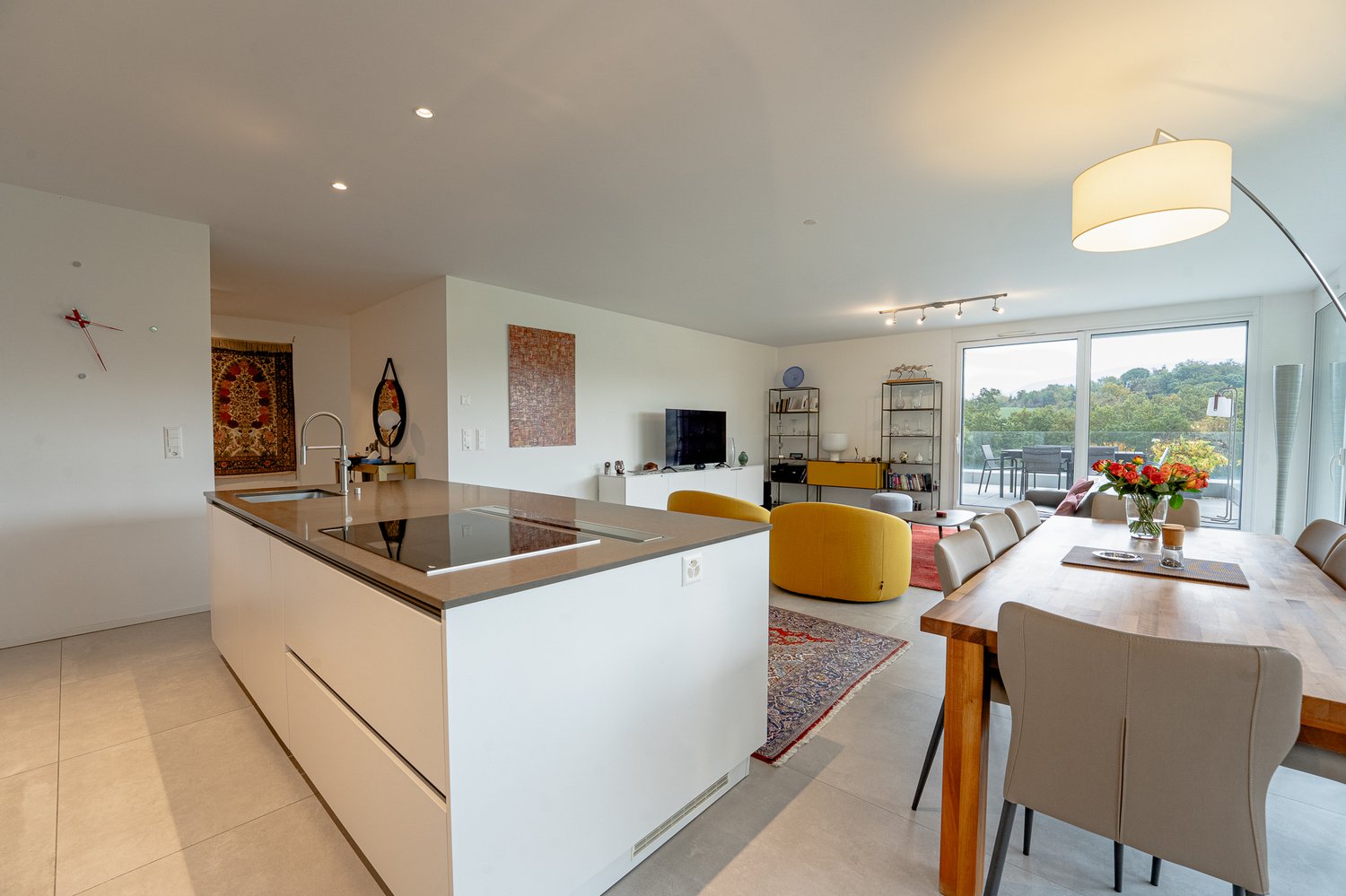 open kitchen with dining area, glass door to balcony, chandelier