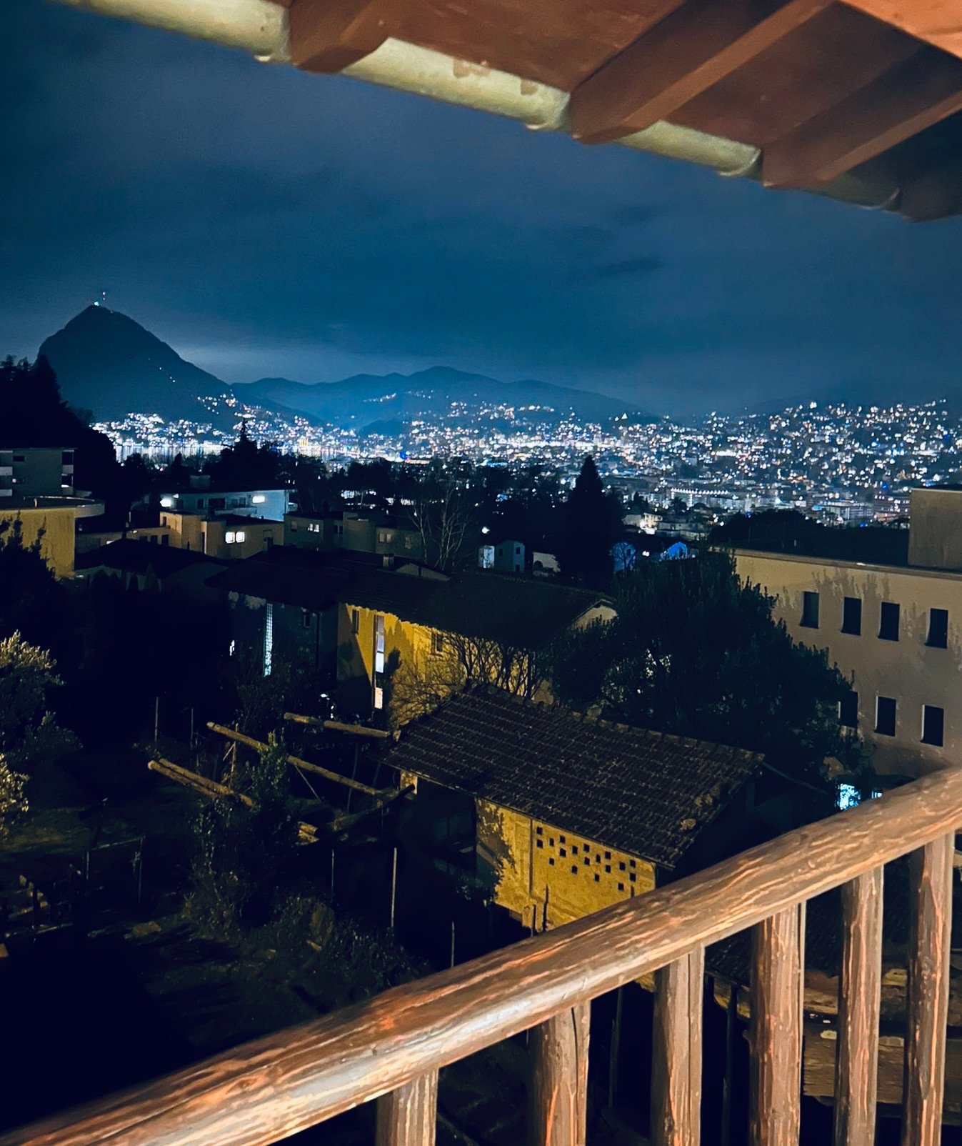 House in neighborhood, balcony, distant mountain and city lights, night view