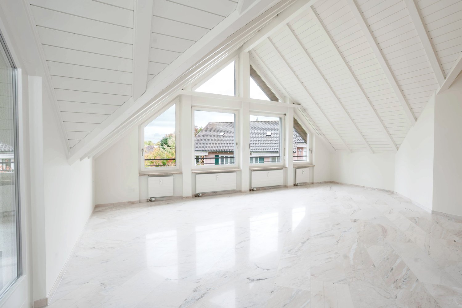 empty room, white walls, white floor, large windows, balcony outside, radiators