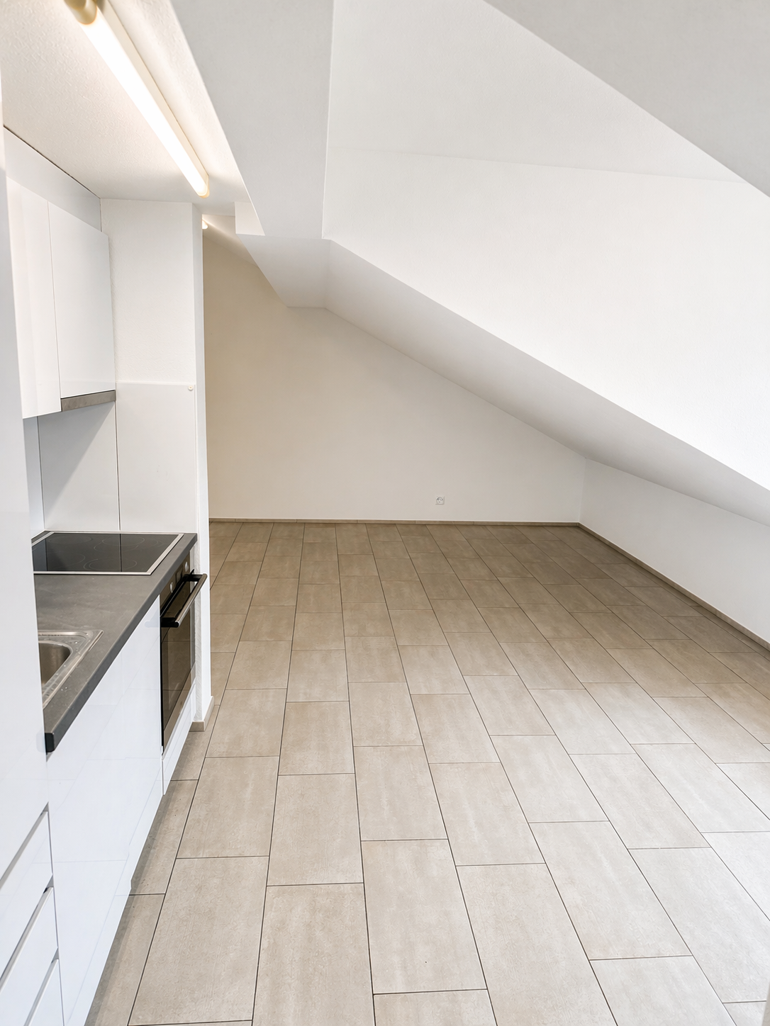 empty kitchen with tiled floor, white cabinets, stainless steel sink, electric stove, ceiling light