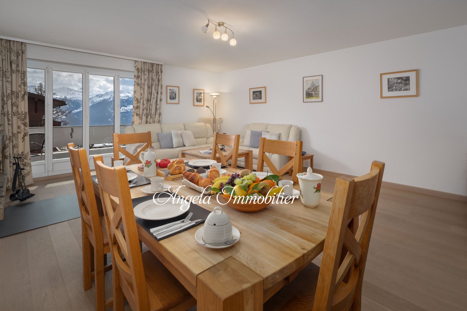 dining table, wooden chairs, large windows, view of mountains, breakfast set, couch, lamp
