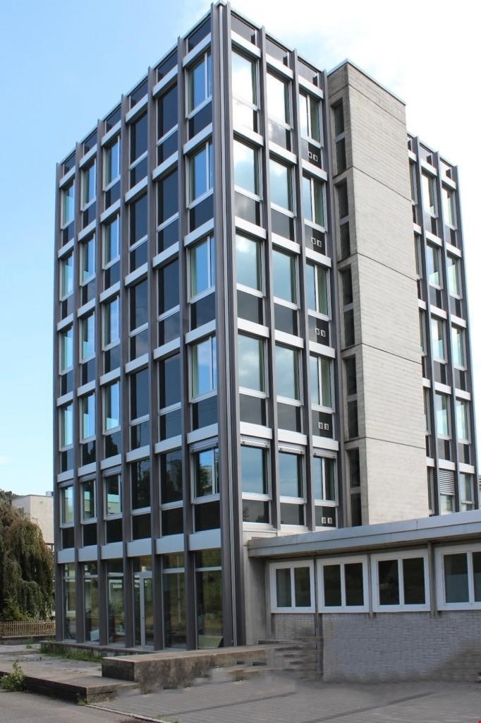 multistory building, glass windows, grey exterior, located in urban area