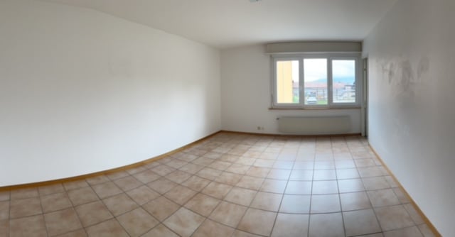 empty room with white walls, tiled floor, large window, heating radiator
