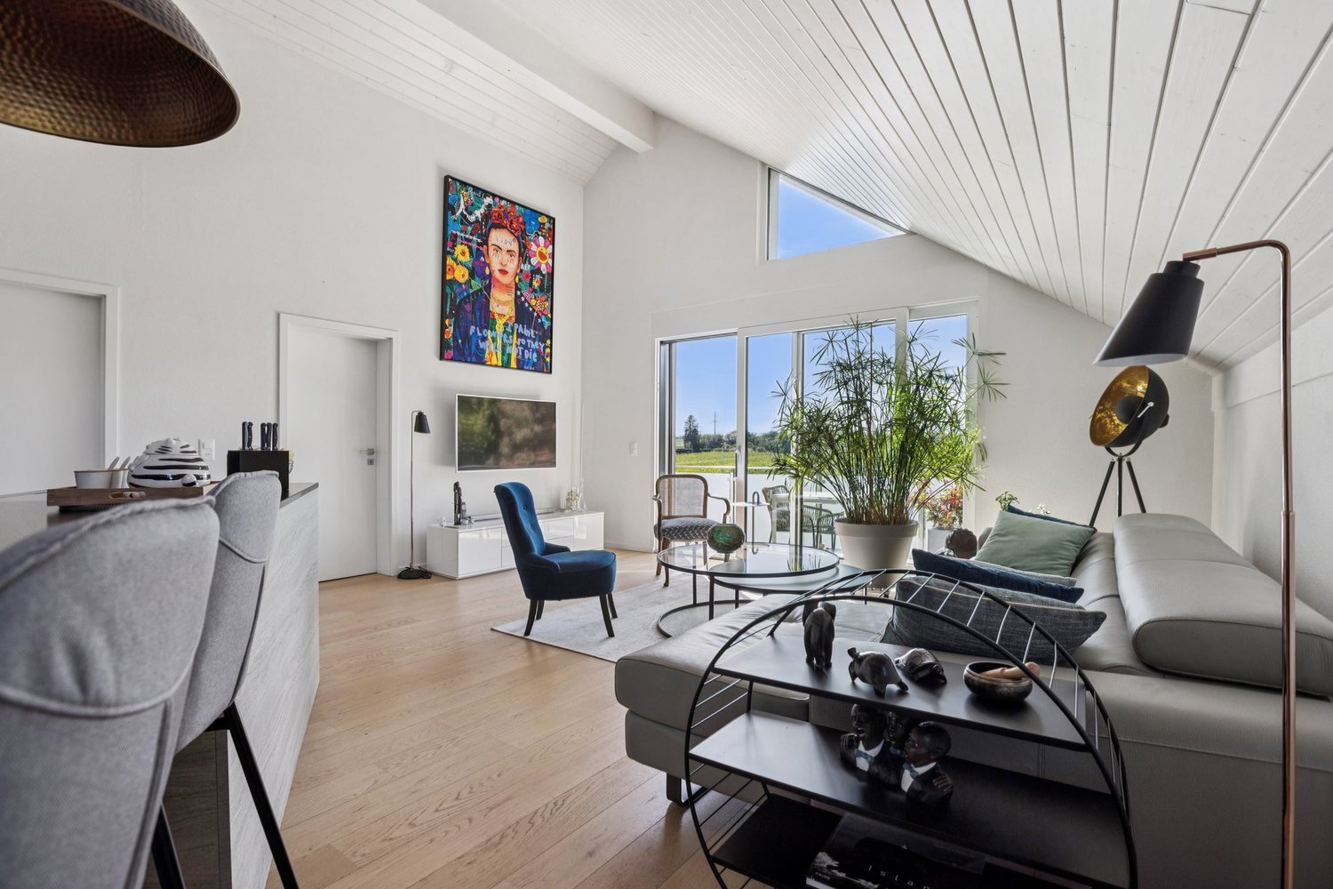 sofa, armchair, coffee table, floor lamp, large windows, artwork