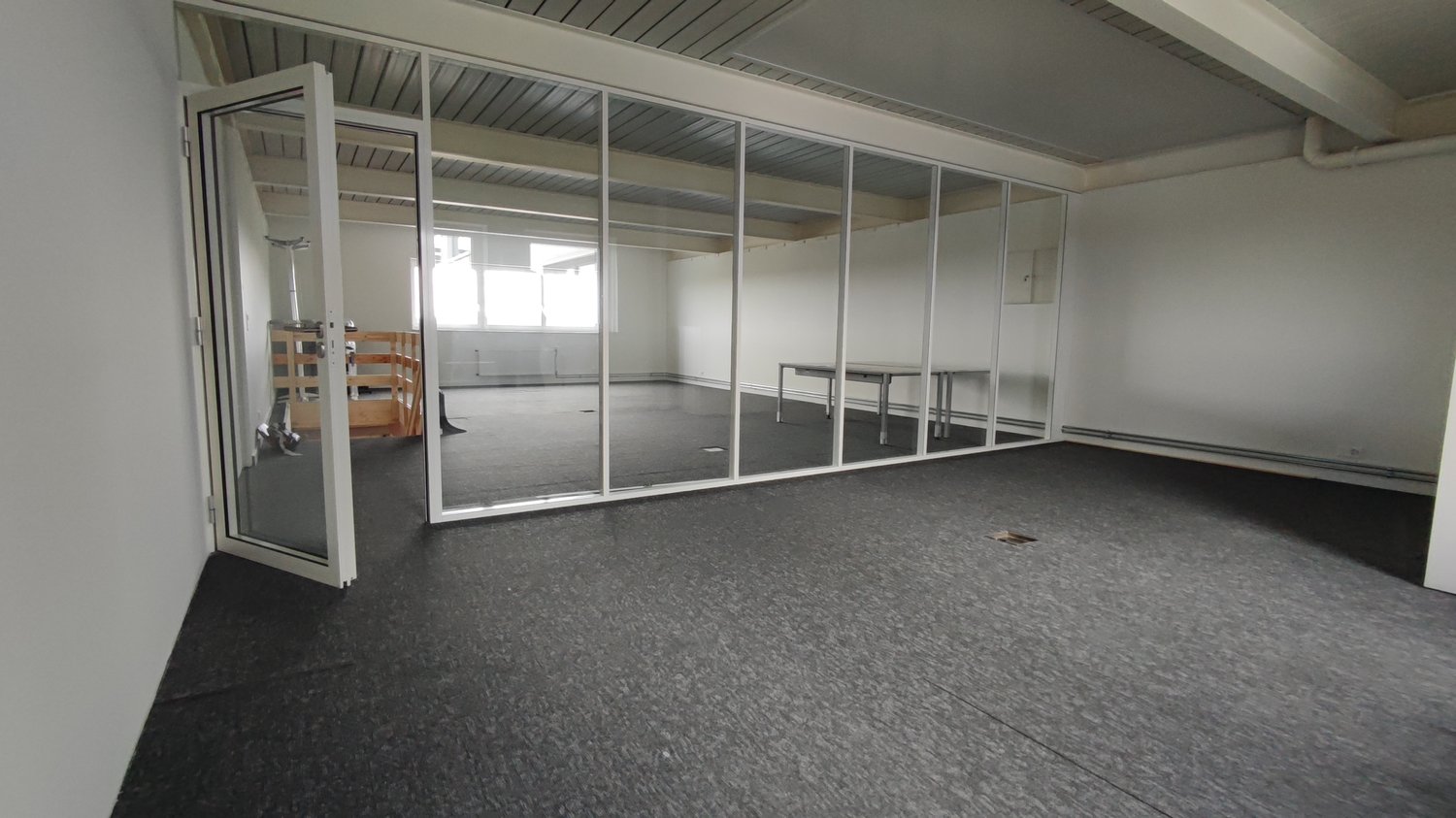 empty room, glass walls, gray floor, white walls, open door, small table, wooden shelf