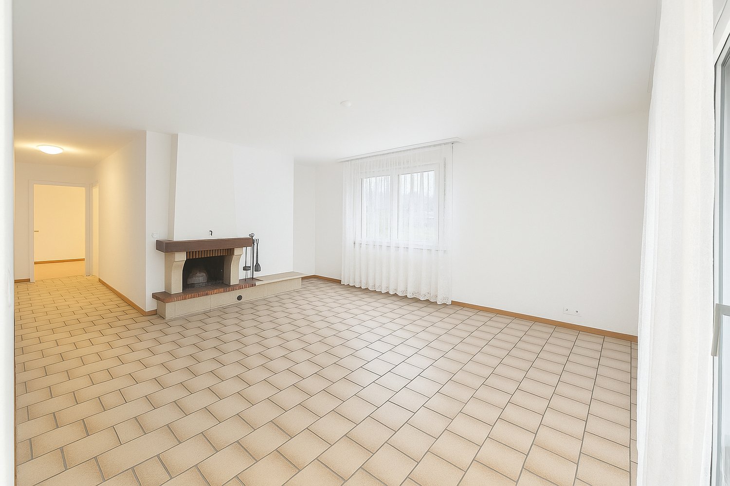 large room, fireplace, tiled floor, white walls, large window with curtains